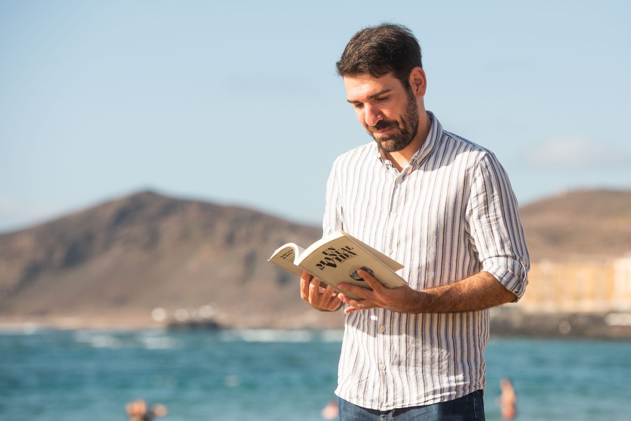 Víctor Gómez leyendo en la playa